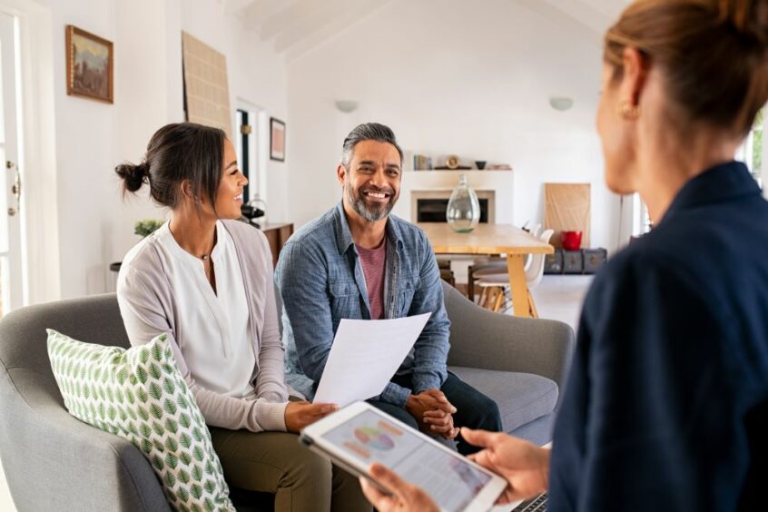 a mixed race couple speaking with a white female financial adviser